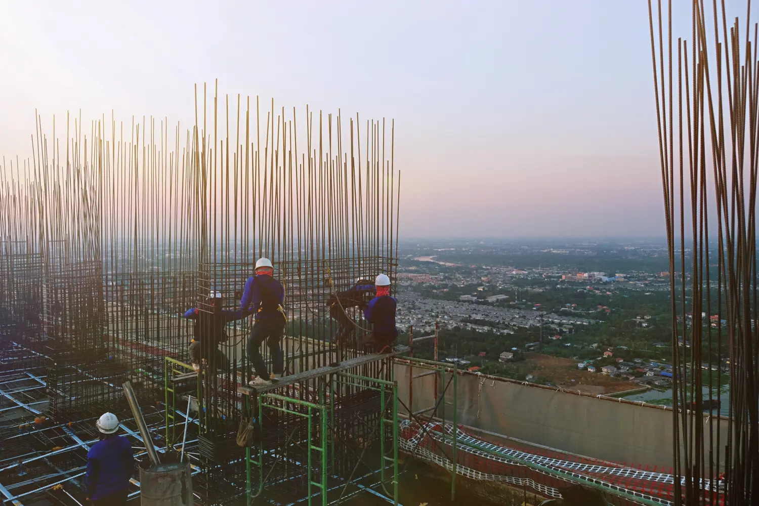 Viele Arbeiter und Angestellte bauen Hochhäuser wie Eigentumswohnungen, Büros und Wohnhäuser, indem sie Zement auf den bereits vorbereiteten Stahl auf dem Dach gießen.